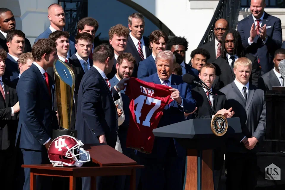 U.S. President Donald Trump receives a team T-shirt from head football coach at Indiana University, Curt Cignetti, as he hosts the 2026 College Football Playoff (CFP) National Champions from Indiana University at the White House in Washington, D.C., U.S., May 11, 2026. REUTERS/Kylie Cooper